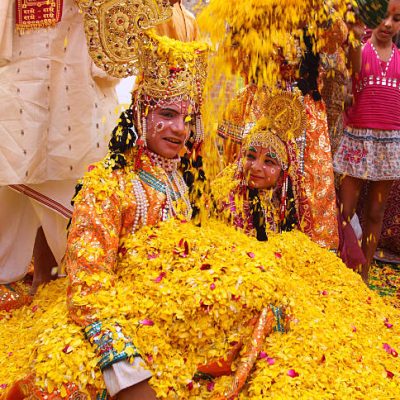 Delhi, India- March 19, 2011: A long forgotten tradition was brought alive at "Delhi Haat" located in New Delhi. The tradition of playing Hoil with flowers. People threw petals of marigold, jasmine and chrysanthemums on each other. In the picture, a pit of young boy and girl poses as Lord Krishna and Radha. Flowers are being showered on the duo.